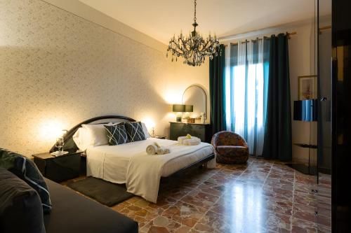 a bedroom with a bed and a chandelier at A Casa di Franca Villa con piscina in Gambassi Terme