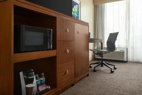 a room with a tv and a chair in a hotel room at Doubletree by Hilton Fort Myers at Bell Tower Shops in Fort Myers