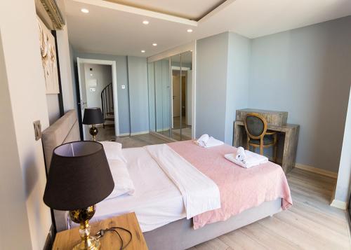 a bedroom with a bed with a lamp and a mirror at Elegance Penthouse by HolidayKeys in Temblos