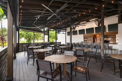 a restaurant with tables and chairs and a library at Doubletree by Hilton Fort Myers at Bell Tower Shops in Fort Myers