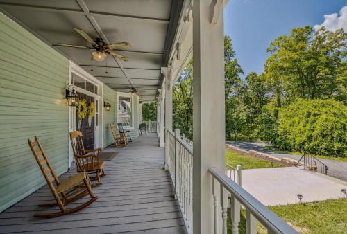 a porch with rocking chairs and a ceiling fan at The Grand Castalian Inn Bed and Breakfast in Berkeley Springs