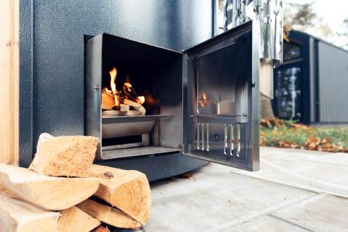 a fireplace with a fire in it on a patio at Sallands natuurhuisje Hellendoorn hottub Metz in Haarle