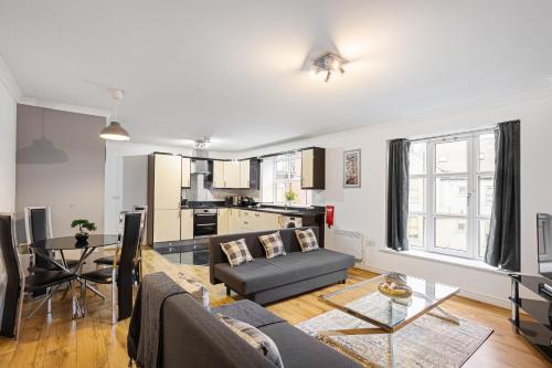 a living room with a couch and a table at Bookbinders Apartments Leeds City Centre in Leeds