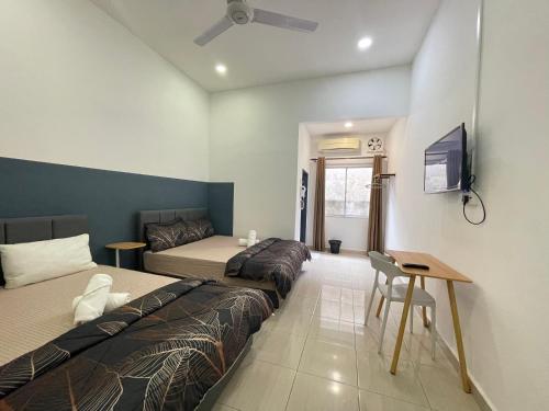 安顺Cozy Roomstay Teluk Intan的一间卧室配有两张床、一张桌子和一台电视。