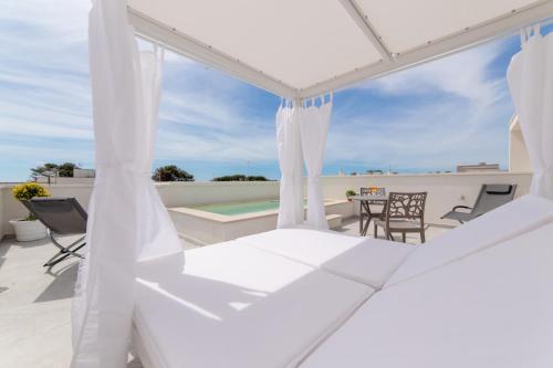 a white porch with chairs and a table at Diva Luxury Suite in Torre San Giovanni Ugento