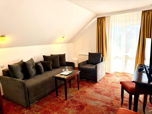 a living room with a couch and a chair at Hotel Piatra Mare in Poiana Brasov