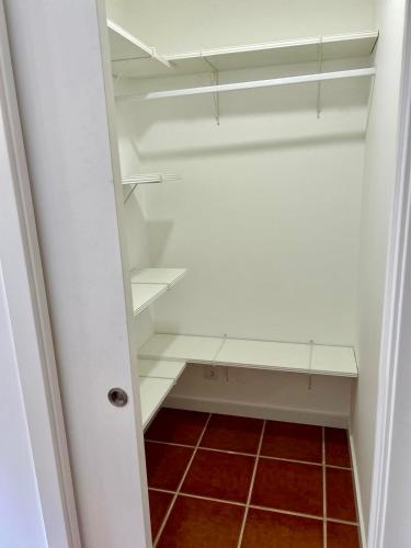 a closet with white shelves and a red tile floor at Grace Villa in Aldeia de Juso