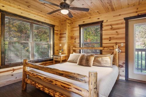 ein Schlafzimmer mit einem Bett in einer Blockhütte in der Unterkunft 10 minutes to Parkway, BunkBeds, Hot Tub, Firepit - Hidden Bear in Starkeytown