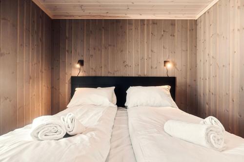 a bedroom with two beds with white sheets and towels at Harevadet 211 in Hornindal