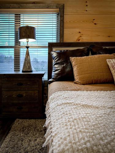 a bedroom with a bed with a lamp and a window at Near Dollywood With Hot Tub, Game Room Home Theater in Sevierville