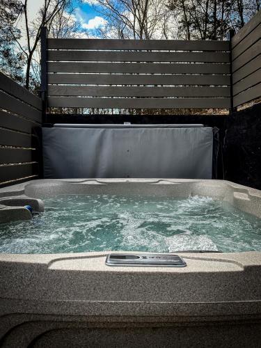 a hot tub with water in front of a fence at Near Dollywood With Hot Tub, Game Room Home Theater in Sevierville