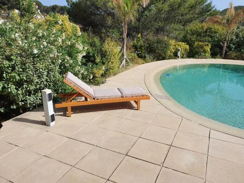 a bench sitting next to a swimming pool at Maison confortable avec piscine à Martigues 93 m² in Martigues