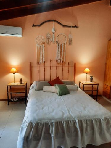 a bedroom with a large bed with two tables at Habitación Suite Sami Llankay in Villa Ciudad Parque
