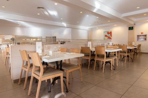 a dining room with tables and chairs in a restaurant at Hipotels Mediterraneo Club in Sa Coma