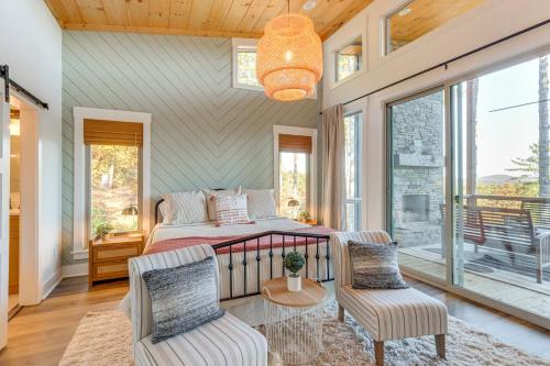ein Schlafzimmer mit einem Bett und zwei Stühlen in der Unterkunft Modern Mtn Cabin with Deck and Views in Blue Ridge! in Blue Ridge