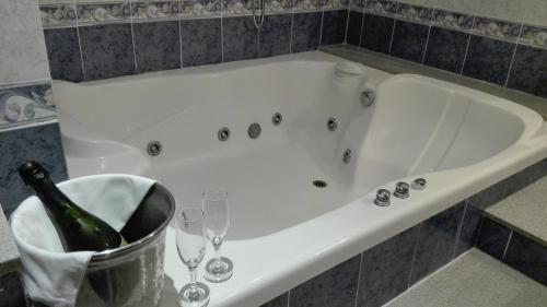 Hostal Andrés في إل سالير: حوض استحمام مع زجاجة من الشمبانيا وكؤوس من النبيذ