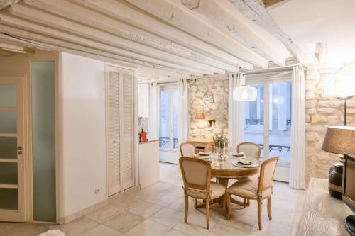une salle à manger avec une table et des chaises dans l'établissement Cosy Appartement en plein Marais, à Paris