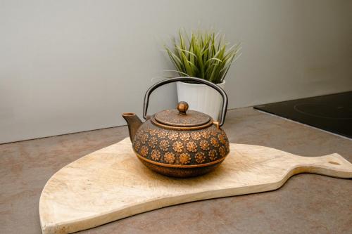 a tea kettle sitting on a wooden board at Terrasse des Monts - Duplex Indépendant de Charme in Les Hôpitaux-Neufs