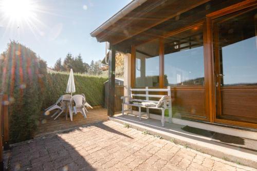 a porch of a house with chairs and an umbrella at Terrasse des Monts - Duplex Indépendant de Charme in Les Hôpitaux-Neufs