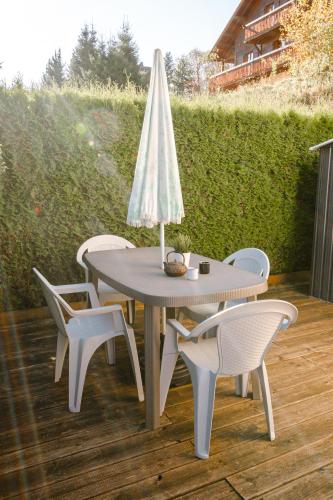 a table and chairs with a lamp on a patio at Terrasse des Monts - Duplex Indépendant de Charme in Les Hôpitaux-Neufs