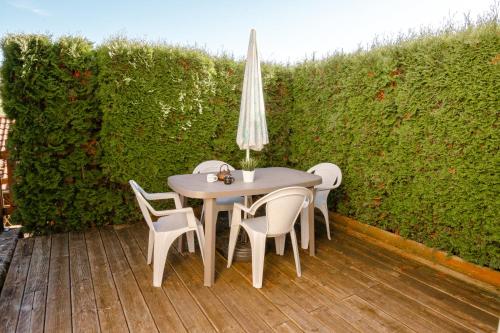 a table with chairs and an umbrella on a patio at Terrasse des Monts - Duplex Indépendant de Charme in Les Hôpitaux-Neufs