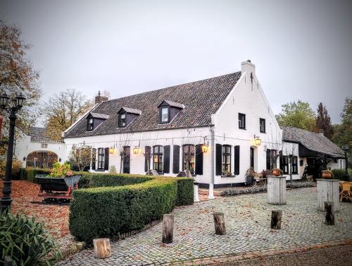 a large white building with a courtyard in front of it at B&B De Grote Waaij in Well