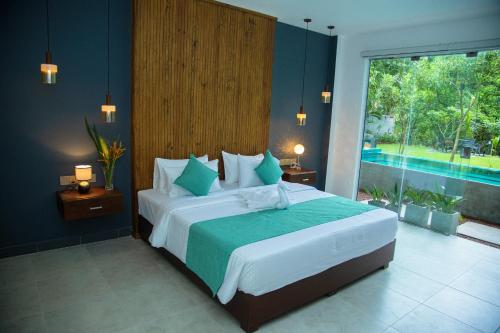 a bedroom with a large bed and a large window at Aaradhya Madu Ganga in Balapitiya