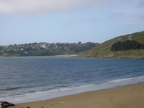 a view of the beach with houses in the distance at Gites Air Marin in Lannion