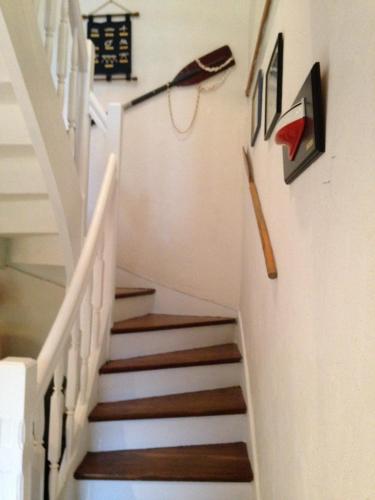 a stairway with white rails and wooden stairs at Gites Air Marin in Lannion