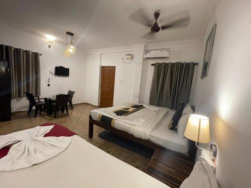 a hotel room with two beds and a ceiling fan at RJ14 Accommodations at Baga Beach in Baga