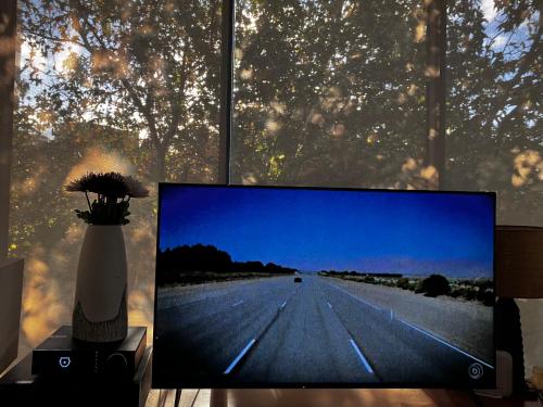 a flat screen tv sitting on a table next to a window at Central Auckland condo, 2Br, 2Brm, pool, gym, study in Auckland