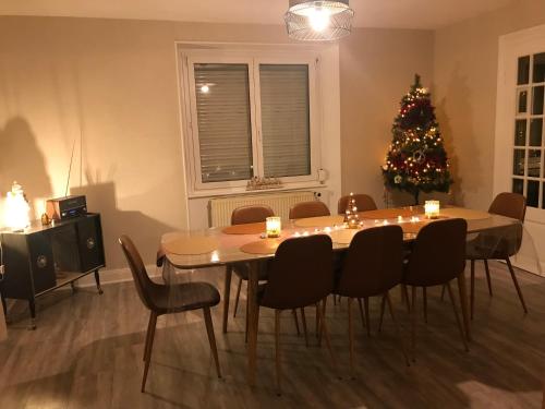 a dining room with a table and a christmas tree at Gîte Monts et Merveilles in Mollau