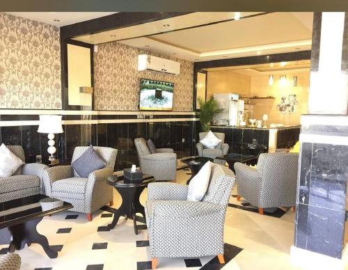 a lobby with chairs and tables and a mirror at اماليا للوحدات السكنية المفروشة in Khamis Mushayt