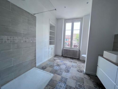 a white bathroom with a shower and a window at La Maison de Colette in Trie-Château