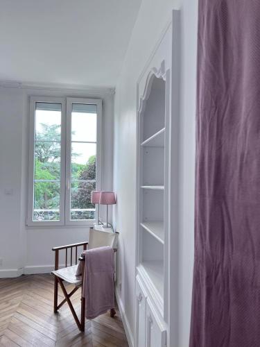 Cette chambre blanche dispose d'une chaise et d'une fenêtre. dans l'établissement La Maison de Colette, à Trie-Château