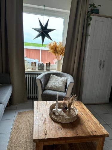 a living room with a coffee table and a star on the window at Strandstern Norddeich in Norddeich