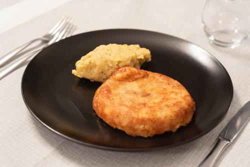 a black plate with two biscuits on a table at Ristorante e B&B IN SELLA in Pozzis