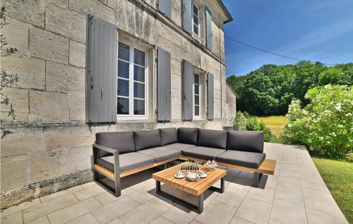 a couch sitting on a patio in front of a building at Awesome Home In Arthenac With Wifi in Arthenac