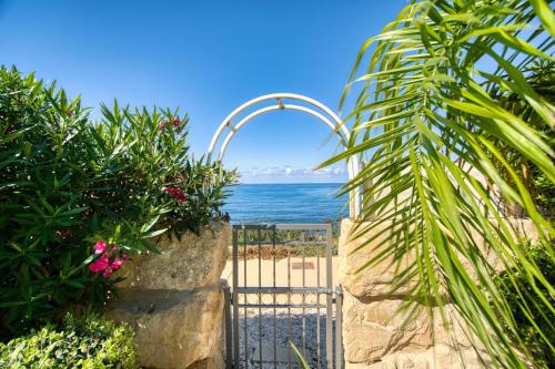 a gate to the beach with the ocean behind it at Seafront Villa 2 in Paphos City