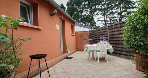 a patio with a table and chairs in a backyard at Gites Air Marin in Lannion