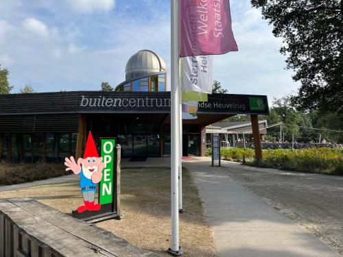 a sign with a gnome on it in front of a building at Sallands natuurhuisje Hellendoorn hottub Metz in Haarle