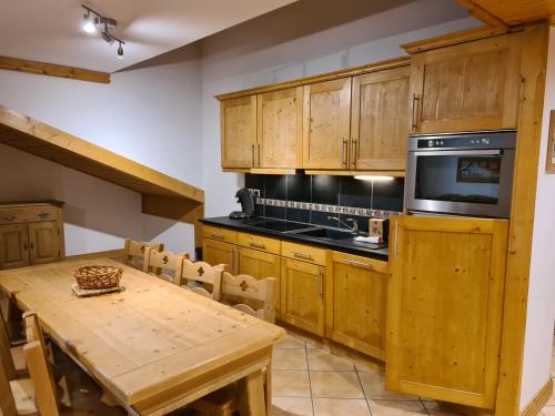 une cuisine avec des armoires en bois et une table en bois dans l'établissement Appartement Le D12 Samoëns, à Samoëns