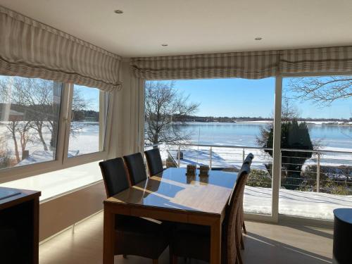 a dining room with a table and a large window at Ferienhaus In Klingberg Mit Seeblick in Scharbeutz