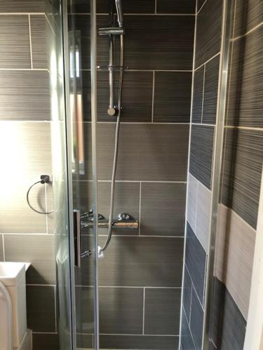 a shower with a glass door in a bathroom at Cosy Heartfelt Room in a Home in Edgware