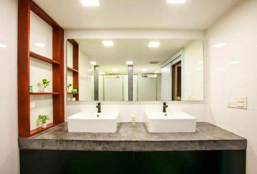 a bathroom with two sinks and a large mirror at Lafami Hostel in Ban Nongdouang