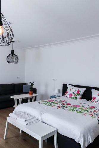 a bedroom with a large white bed and a couch at Bij Jans in Hilvarenbeek