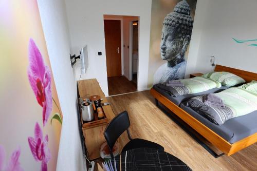 a room with a bed with a statue of a head at Carpediem Apartments in Schönwald