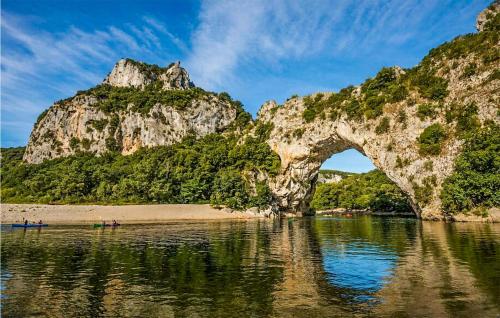 an arch in the water next to a beach with trees at Beautiful Apartment In Vallon Pont Darc in Vallon-Pont-dʼArc
