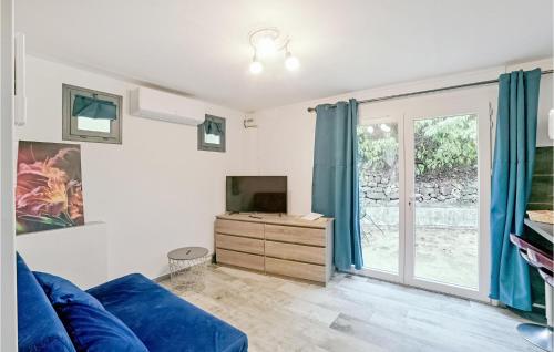 - un salon avec un canapé bleu et une porte coulissante en verre dans l'établissement Beautiful Apartment In Vallon Pont Darc, à Vallon-Pont-dʼArc