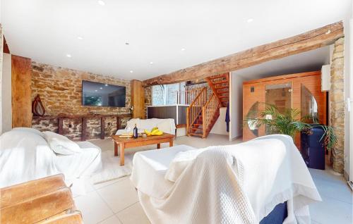 Il comprend un salon doté d'un mobilier blanc et d'un mur en briques. dans l'établissement Amazing Home In St-Hilaire-Le-Château, à Saint-Hilaire-le-Château